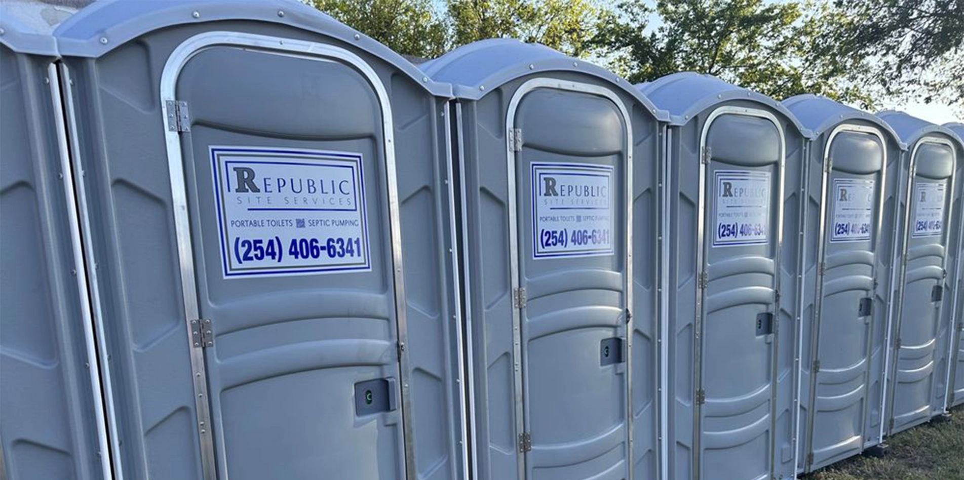 Row of Gray Portable Restrooms with Republic Site Services Branding