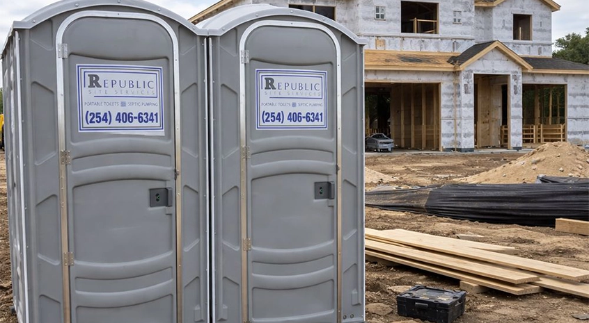Line of portable toilets arranged along a gravel lot in McGregor
