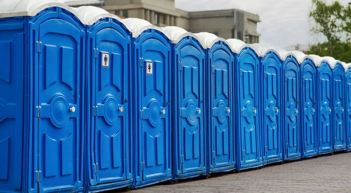 Row of Blue Portable Restrooms Aligned Outdoors