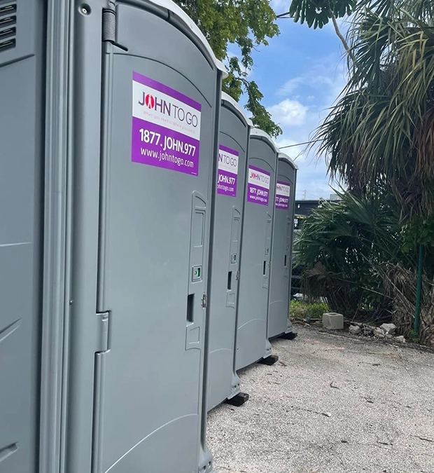Row of Portable Toilet Rentals Under Palm Trees