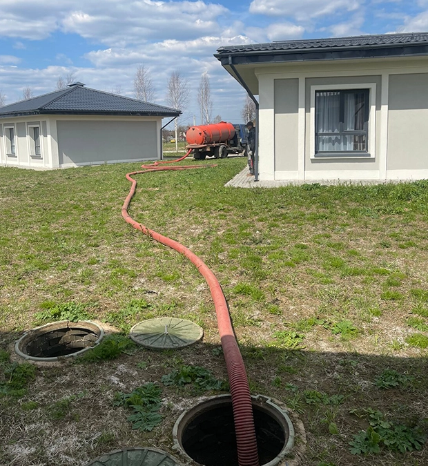 Hose Connected for Septic Pumping Services Between Two Residential Buildings