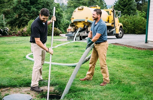 Technicians Performing Septic Pumping Services with Yellow Vacuum Truck Nearby