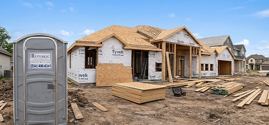 Construction Site with Portable Restroom and Partially Built House